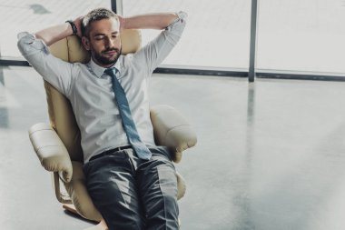 Lüks koltuk modern ofisindeki tarihinde yakışıklı işadamı rahatlatıcı yüksek açılı görünüş