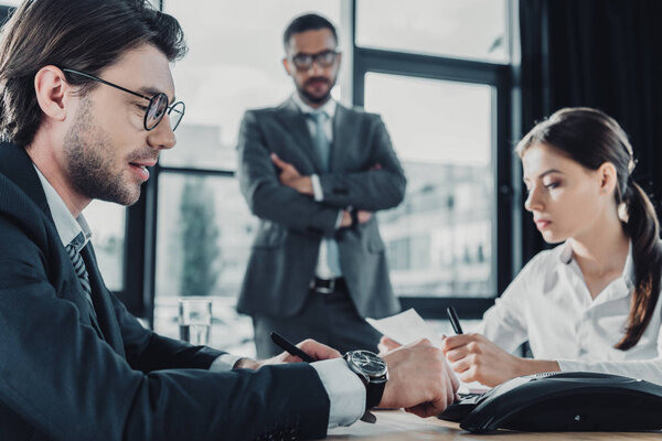 уверенные деловые люди, работающие вместе в конференц-зале в современном офисе
