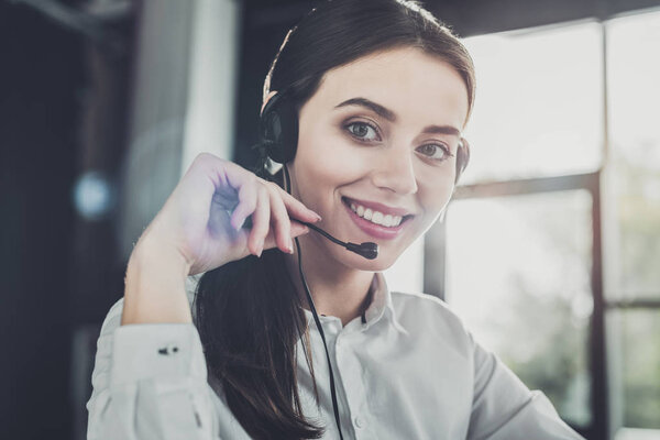 beautiful female call center worker with headphones looking at camera