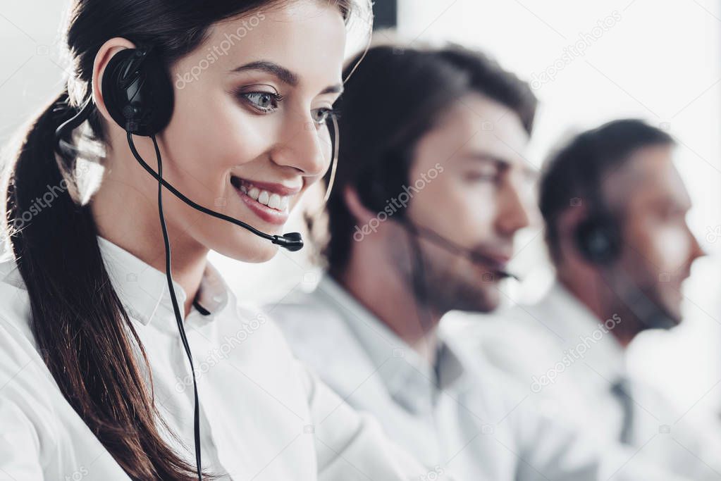 smiling young call center manageress working with colleagues