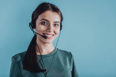 attractive smiling female call center worker looking at camera isolated on blue clipart