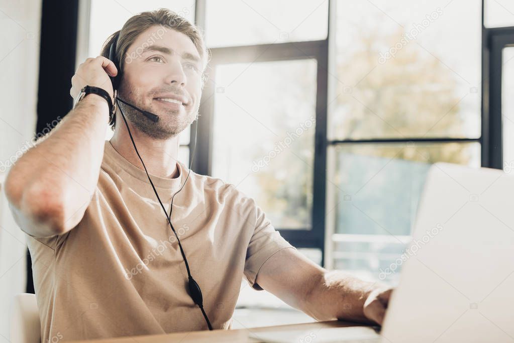 handsome young call center worker working at modern office