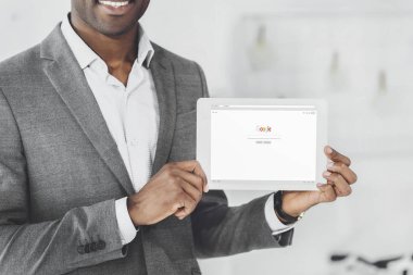 Afrika kökenli Amerikalı adam tablet yüklü google sayfası ile gösterilen gülümseyen bir görüntü kırpılmış