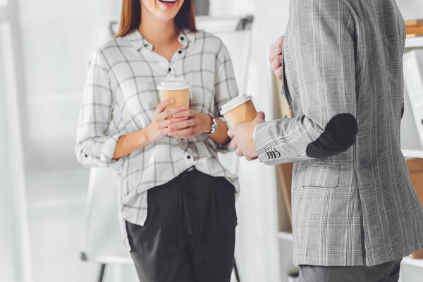 cropped image of male and female colleagues having coffee break in office