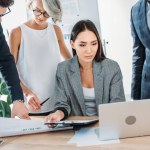 Multiethnic businesspeople using laptop during meeting in office Multiethnic businesspeople using laptop during meeting in office