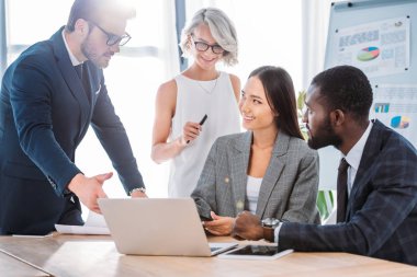 Office proje üzerinde ve laptop arıyorum çok ırklı iş adamları gülümseyen