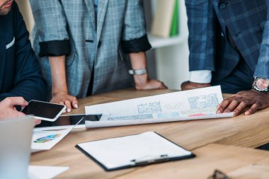Tablo belgeleri ve araçları Office yakınındaki çok kültürlü iş adamları kırpılmış görüntü