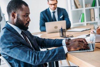 çok kültürlü işadamları Office masada dizüstü bilgisayarlar kullanarak