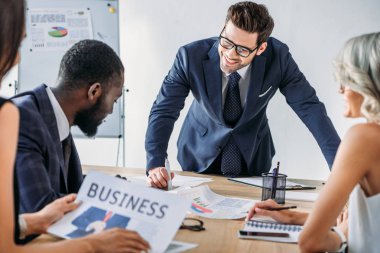 Office proje üzerinde çok kültürlü iş adamları gülümseyen genç