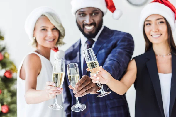 Mnohonárodnostní Podnikatelé Santa Klobouky Cinkání Sklenic Šampaňského Kanceláři Při Pohledu — Stock fotografie zdarma