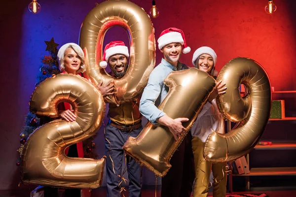 年轻的多文化商人在圣诞老人帽子举行2019气球在新年企业党 — 图库照片