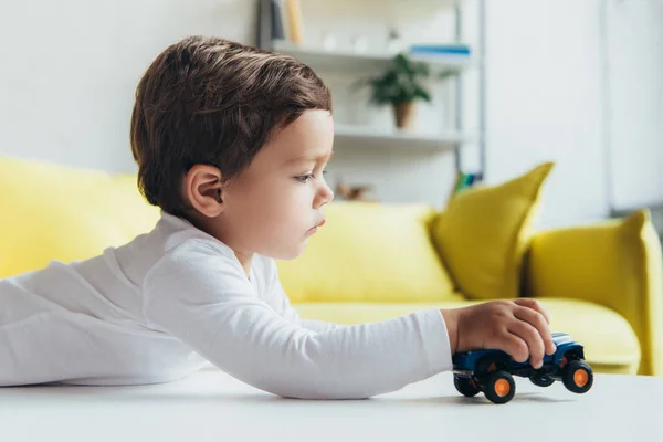 自宅のおもちゃの車で遊ぶ愛らしい少年 — ストック写真