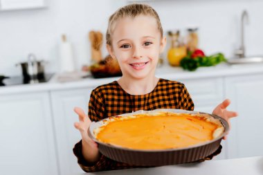 mutlu Şükran günü pasta ile fırın tepsisi tutan küçük bir çocuk