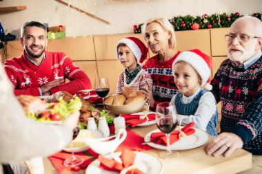 görüntü kadın taşıma yemek masasında mutlu aile ile Noel yemeği için kırpılmış