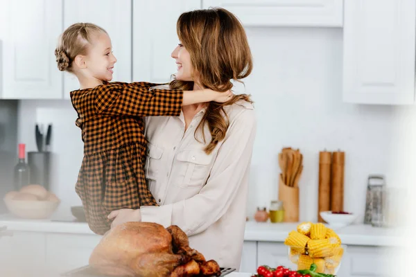 Feliz Jovem Mãe Filha Abraçando Enquanto Cozinhar Peru Ação Graças — Fotografia de Stock