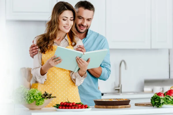 Lyckligt Par Läsa Receptbok Medan Matlagning Tillsammans Kök — Stockfoto