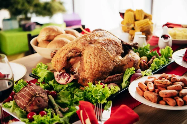感謝祭のお祝いにおいしい料理を提供していますテーブルの上トルコを焼き — ストック写真
