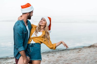kaç sarılma ve plajda eğlenmek santa şapkalar içinde