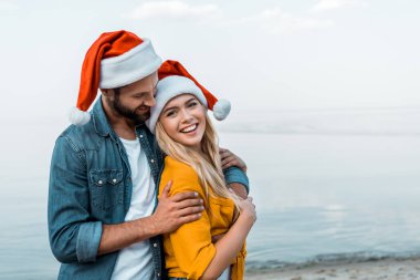 santa şapka kucaklama kız sahilde erkek gülümseyen