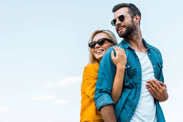 Vista Ángulo Bajo Novia Sonriente Abrazando Novio Contra Cielo Azul — Foto de Stock