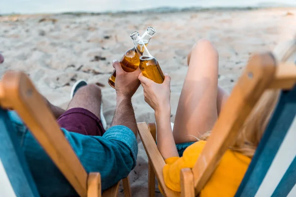 サンラウン ジャーで座っていると 砂浜でビールの入ったガラス瓶をチリンとカップルの画像をトリミング — ストック写真