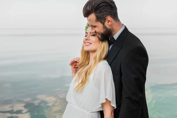 Happy Wedding Couple Suit White Dress Hugging Beach — Stock Photo, Image