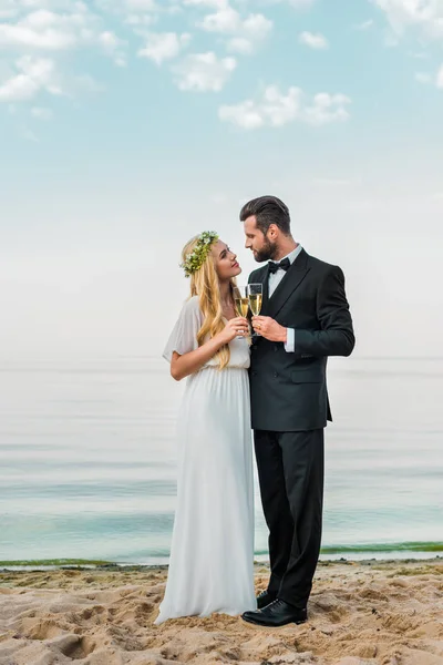 Bruidspaar Rammelende Met Glazen Champagne Strand Kijken Naar Elkaar — Stockfoto