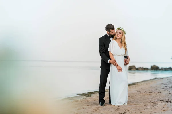 Noivo Terno Abraçando Noiva Atraente Vestido Branco Praia — Fotografia de Stock