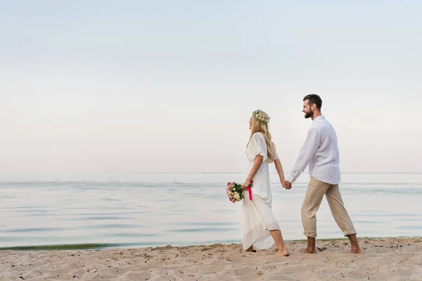 Vista Lateral Noiva Noivo Mãos Dadas Andando Com Buquê Casamento — Fotografia de Stock