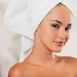 Gorgeous woman relaxing with towel on head at spa salon