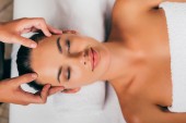 Lächelnde Frau entspannt sich im Massagesalon 
