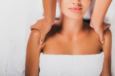 cropped view of relaxing woman having shoulders massage at spa salon