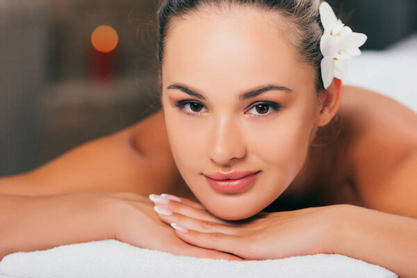 beautiful woman smiling at spa salon and looking at camera