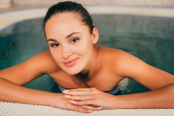 Yüzme Havuzunda Rahatlatıcı Kameraya Bakarak Güzel Kadın — Stok fotoğraf