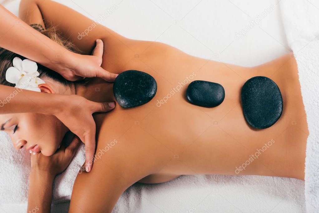 attractive woman having stone therapy at spa salon 