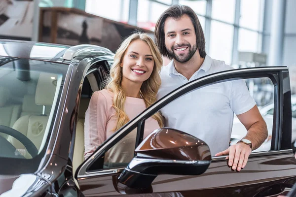 Portrait Smiling Couple Standing New Car Dealership Salon — Stock Photo, Image