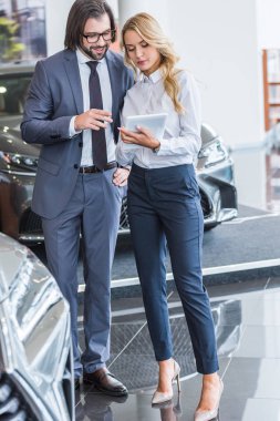 kadın auto salon satıcı ile işadamı araba bayilik salonu seçmek için yardımcı tablet