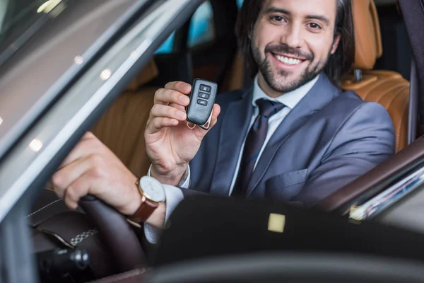 Portrait Smiling Businessman Car Key Hand Sitting New Car Dealership — Stock Photo, Image