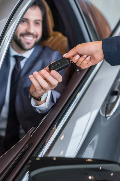 Gedeeltelijke Weergave Van Vrouwelijke Verkoper Auto Sleutel Geven Lachende Zakenman — Stockfoto