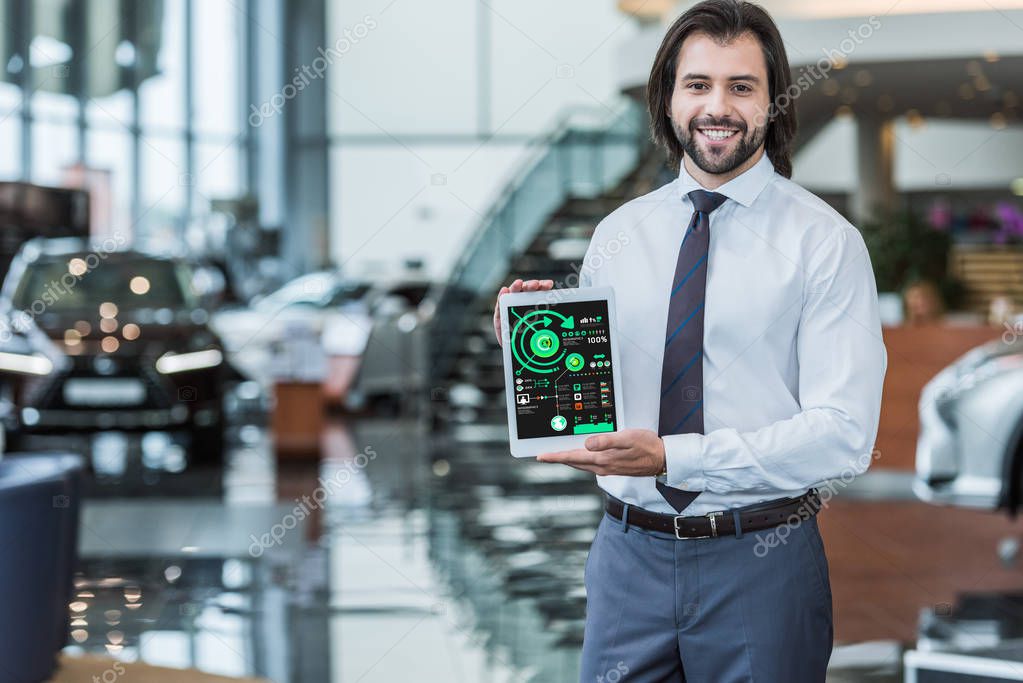 Smiling dealership salon seller in formal wear showing tablet with infographic in hands