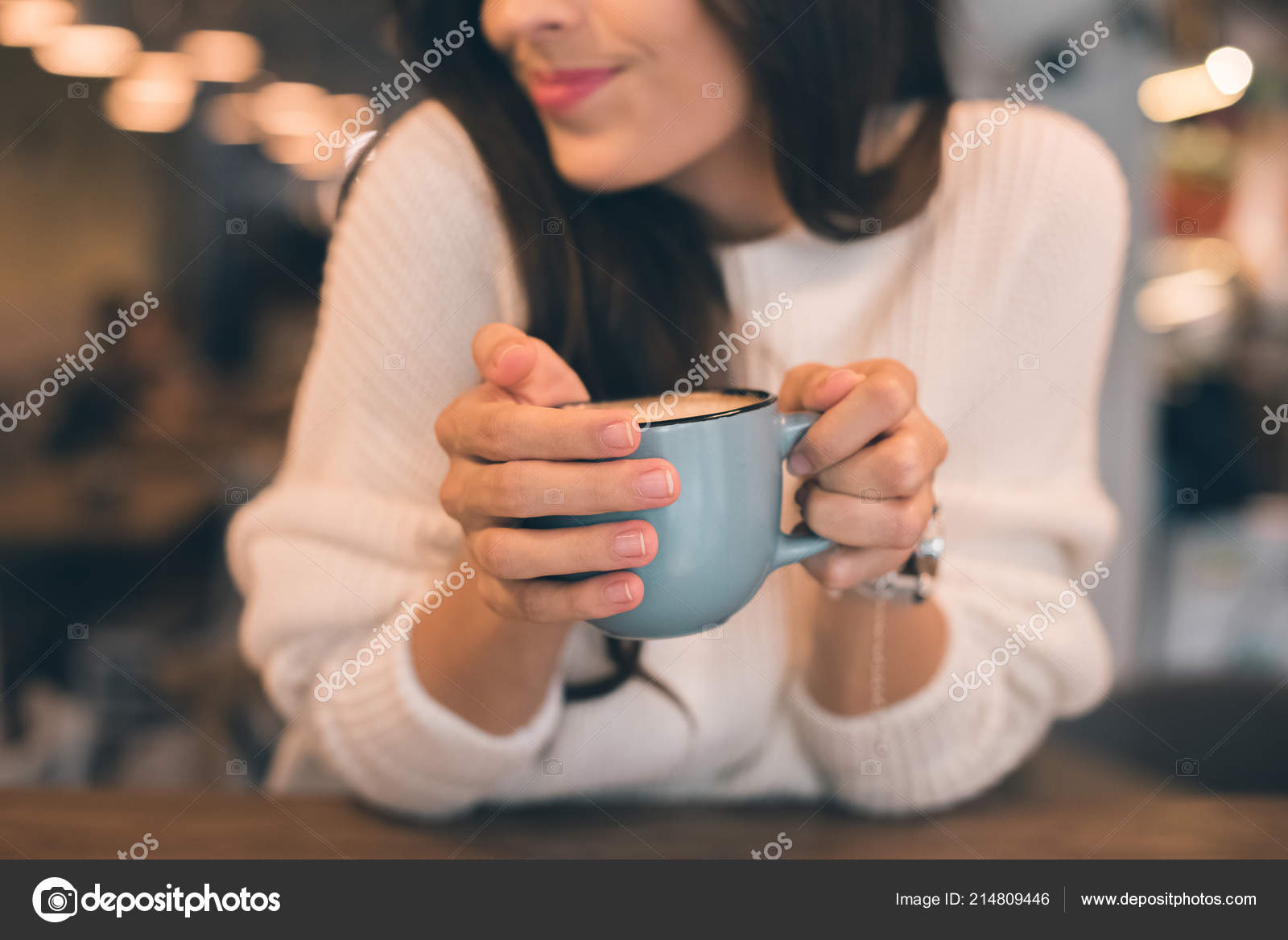 mulher jovem e bonita com uma xícara de café de plástico na mão de