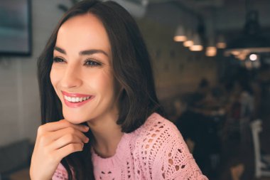 kafede masada oturan genç gülümseyen kadın portresi kapatın