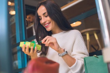gülümseyen genç kadın çözmeyi hediye kutusu Cafe