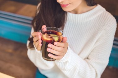 kısmi bir kafede masada mulled şarap tutan genç kadın görünümünü