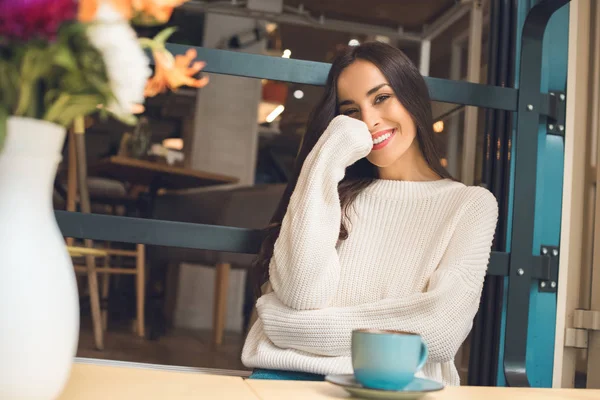 Счастливая Привлекательная Молодая Женщина Смотрит Камеру Столом Чашкой Кофе Кафе — стоковое фото