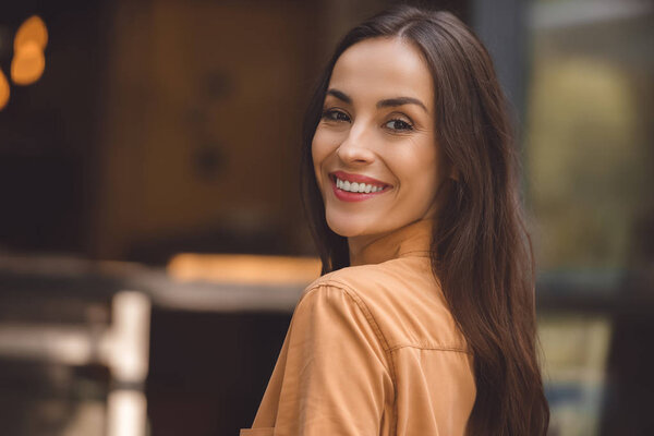 selective focus of beautiful stylish woman looking at camera at urban street 