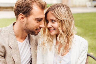 kafede oturan ve birbirine bakarak sonbahar kıyafeti sevmek çift