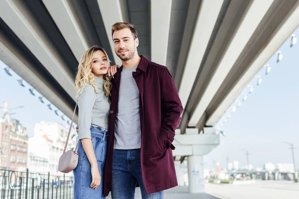 Stylish Couple Autumn Outfit Hugging Bridge City Looking Camera — Stock Photo, Image