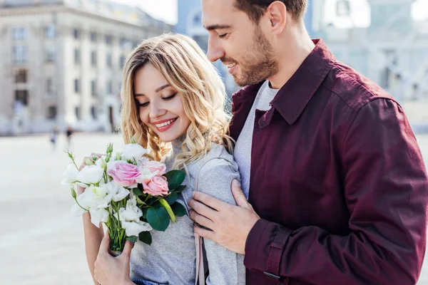 Guapo Novio Abrazando Atractiva Novia Con Ramo Ciudad — Foto de Stock