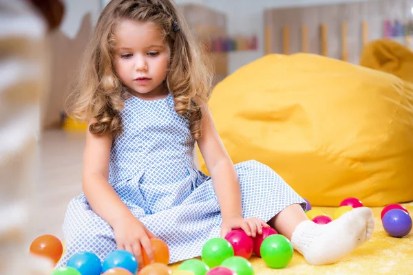 Criança Adorável Sentado Tapete Olhando Para Bolas Coloridas Jardim Infância — Fotografia de Stock